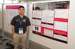 A student stands in front of his presentation at SURC 2026
