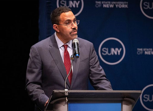 SUNY Chancellor John B King Jr speaks at a podium.