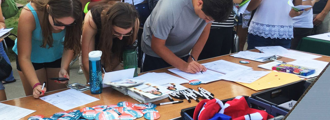 Students at a table registering to vote. 