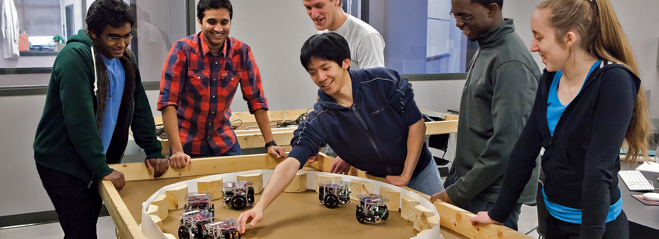 Binghamton University students work on science robotics in lab. 